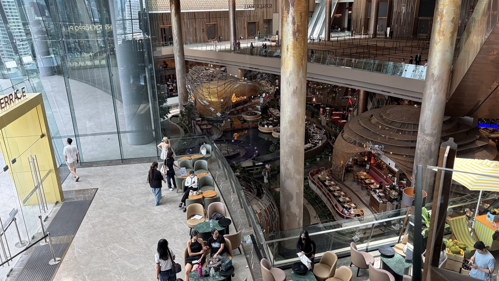 上階の窓際から見下ろした ICONSIAM の吹き抜け。下層階に伝統的な意匠の飲食エリアが広がる