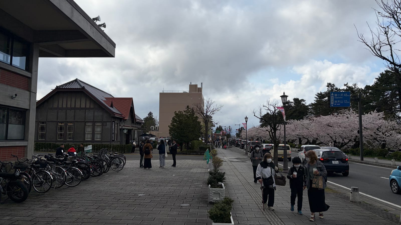 通りから見た弘前公園前店周辺。桜並木と花見客でにぎわう