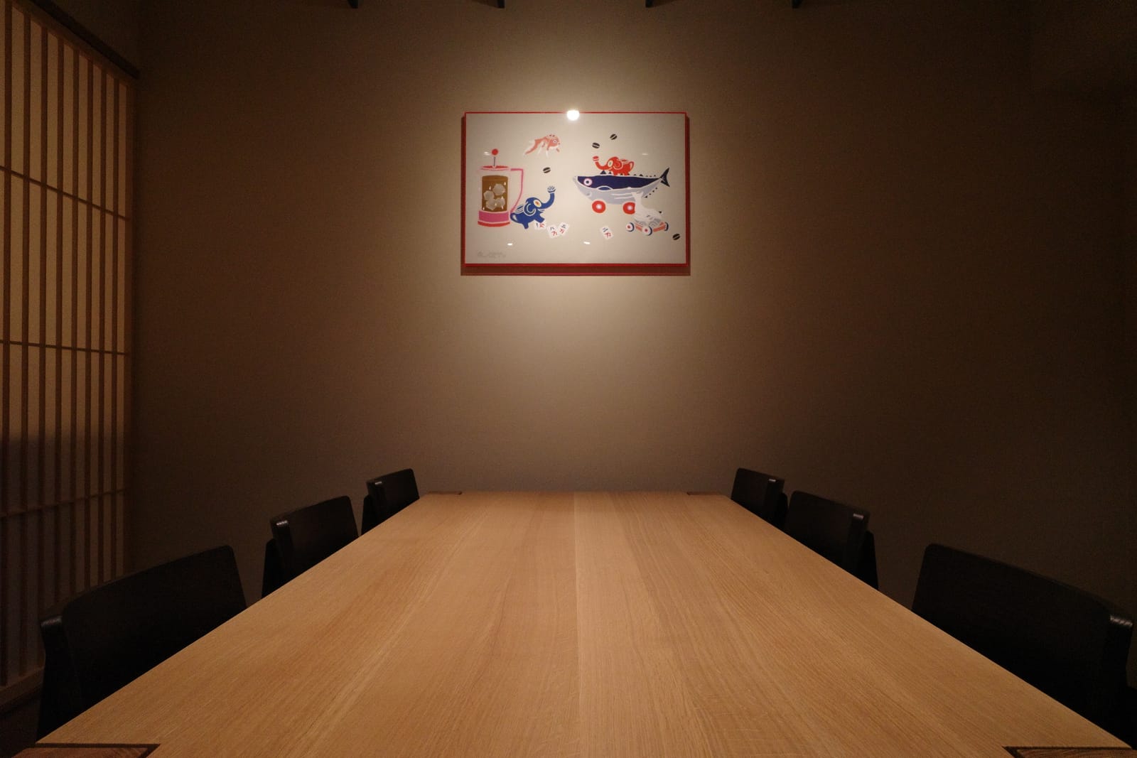 地下のコミュナルテーブル。壁のアートと一緒に座ると一枚の絵のような構図になる