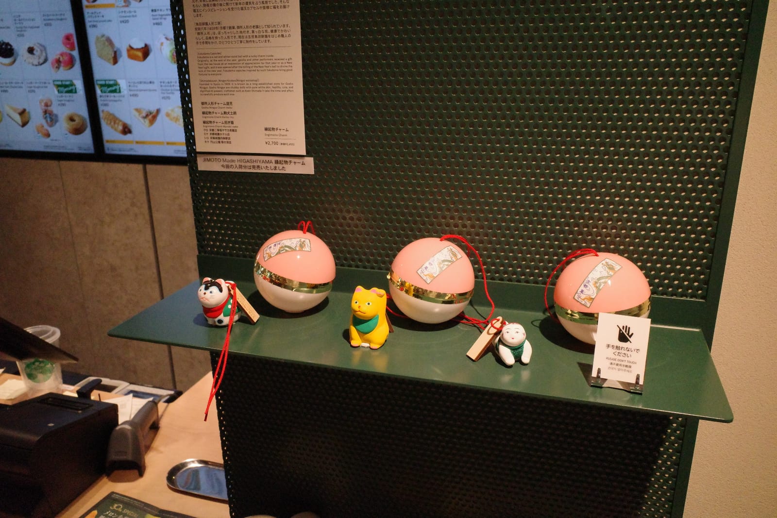 福玉カプセルと縁起物チャームのディスプレイ。ピンクのカプセルの前に各種チャームが並ぶ