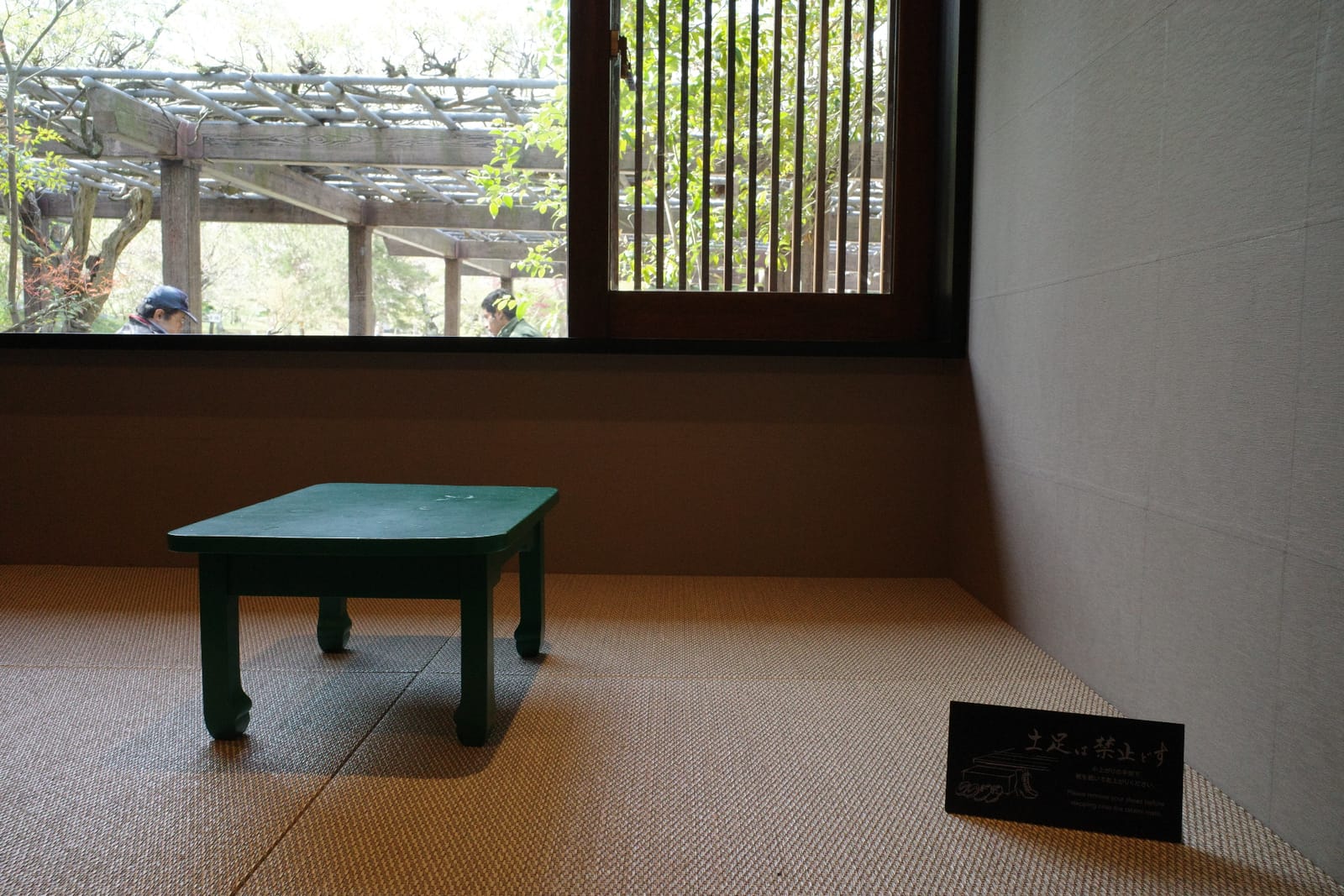畳の「御座の席」。小さなちゃぶ台が置かれ、窓の外には藤棚が広がる