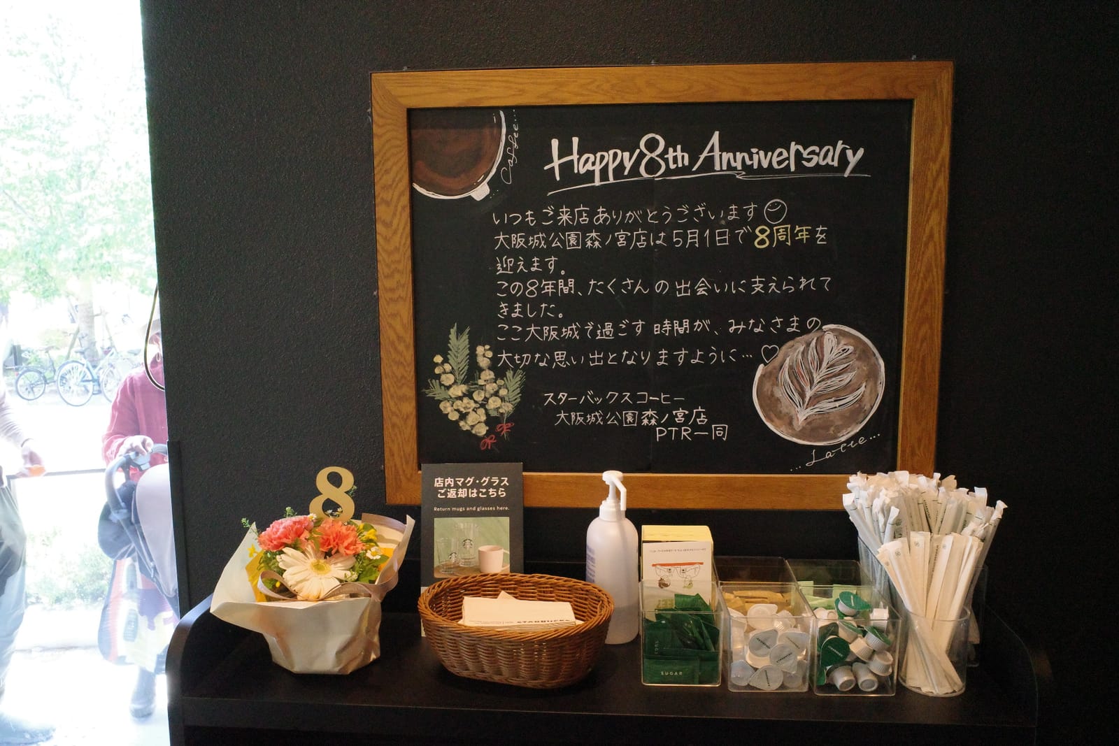 店内の黒板アート「Happy 8th Anniversary」。大阪城公園森ノ宮店は5月1日で8周年を迎えるというパートナーからのメッセージ、足元には小さな花束と「8」のオブジェ