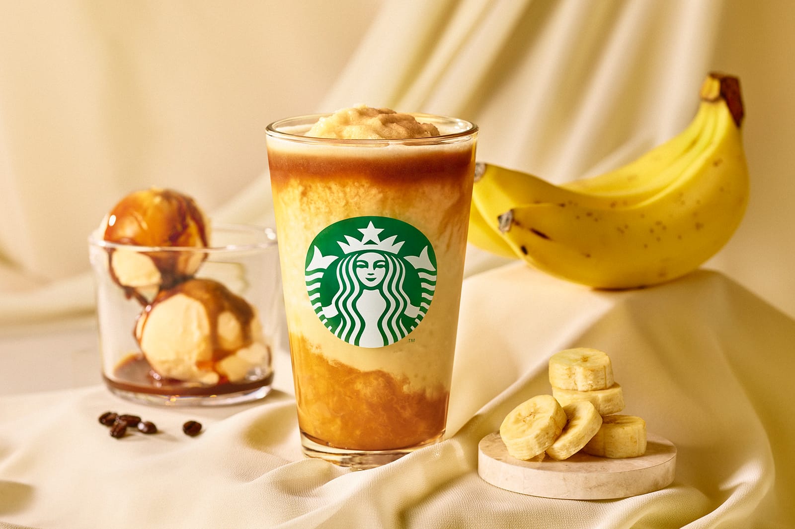 バナナ アフォガート フラペチーノ®の商品写真。透明カップに入ったバナナ色のフラペチーノとエスプレッソが添えられている